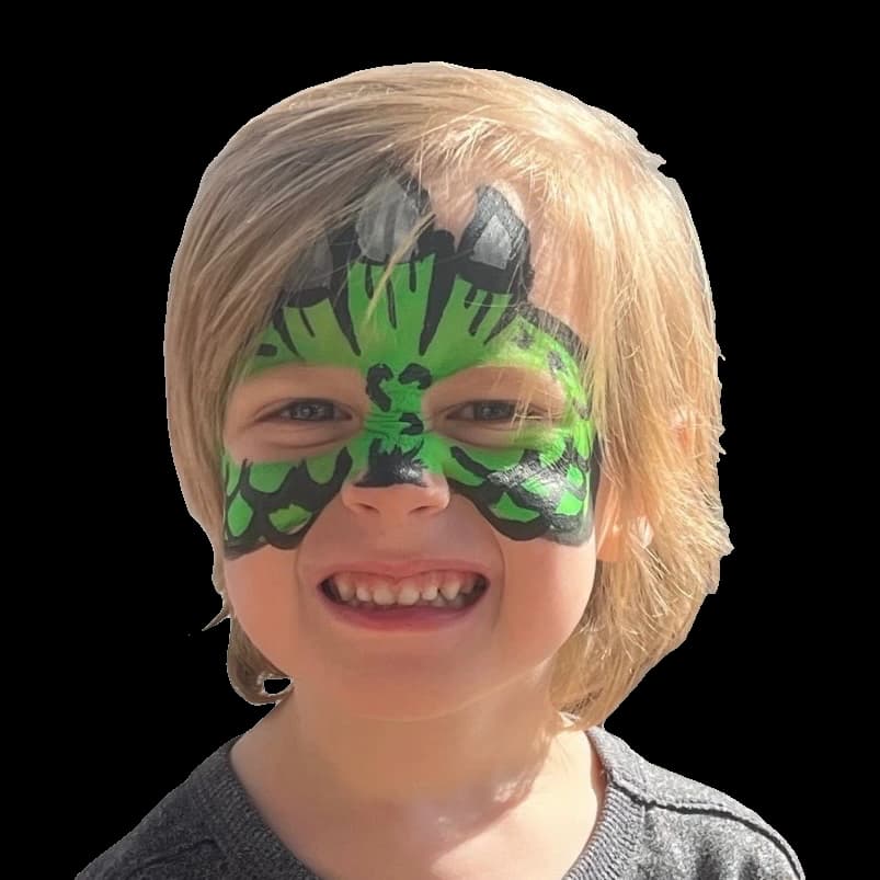 Smiling child wearing a bright green superhero-inspired face painting design.