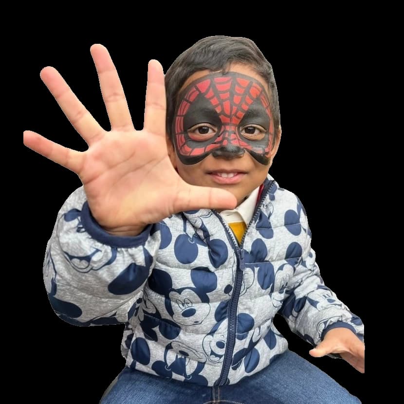 Child wearing a red and black spider-inspired face painting design.