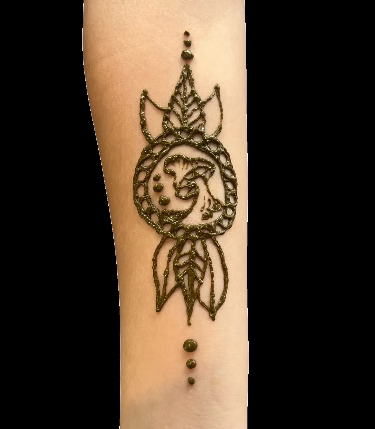 Moon and leaves henna design centered on a forearm.